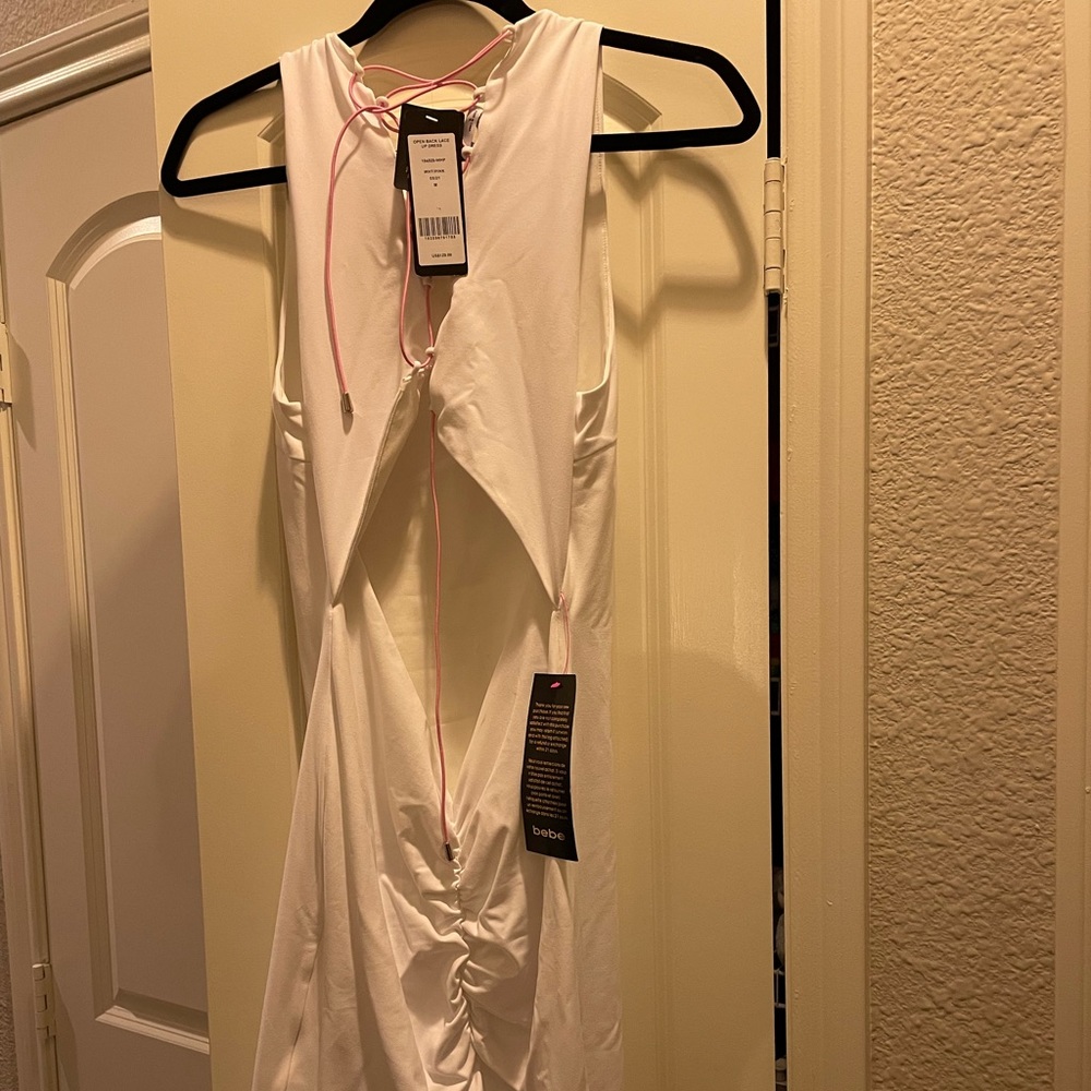 Bebe white sleeveless backless dress with pink laces in back. NWT.